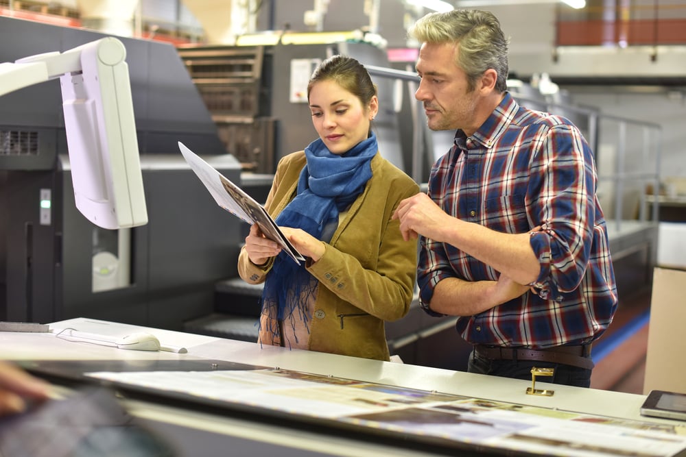 woman-and-man-reviewing-blueprints-in-factory
